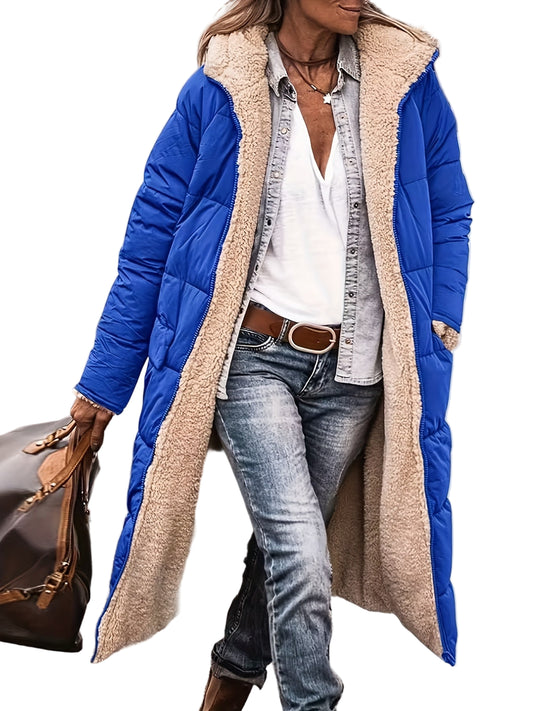 Person wearing a long blue and beige puffer coat with jeans and a white shirt.
