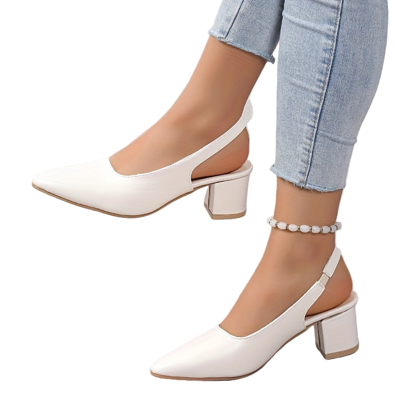 White slingback heels worn with light blue jeans on a neutral background