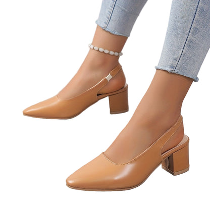 Tan high-heeled shoes worn with light blue jeans on a neutral background