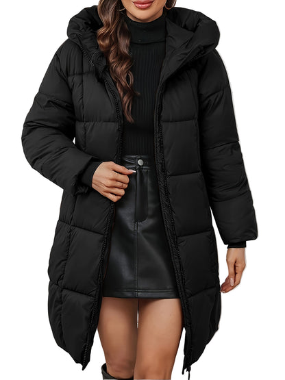 Person wearing a long black puffer coat over a black outfit with a white background