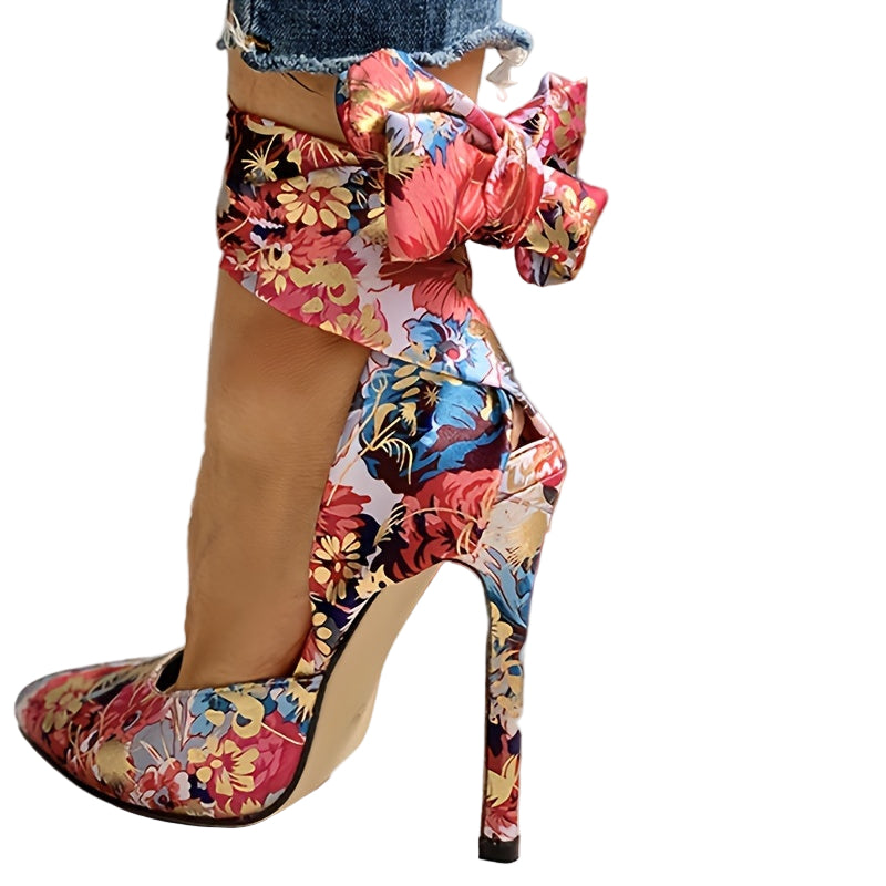 Colorful floral high-heeled shoes with a measurement label on a light wooden floor.