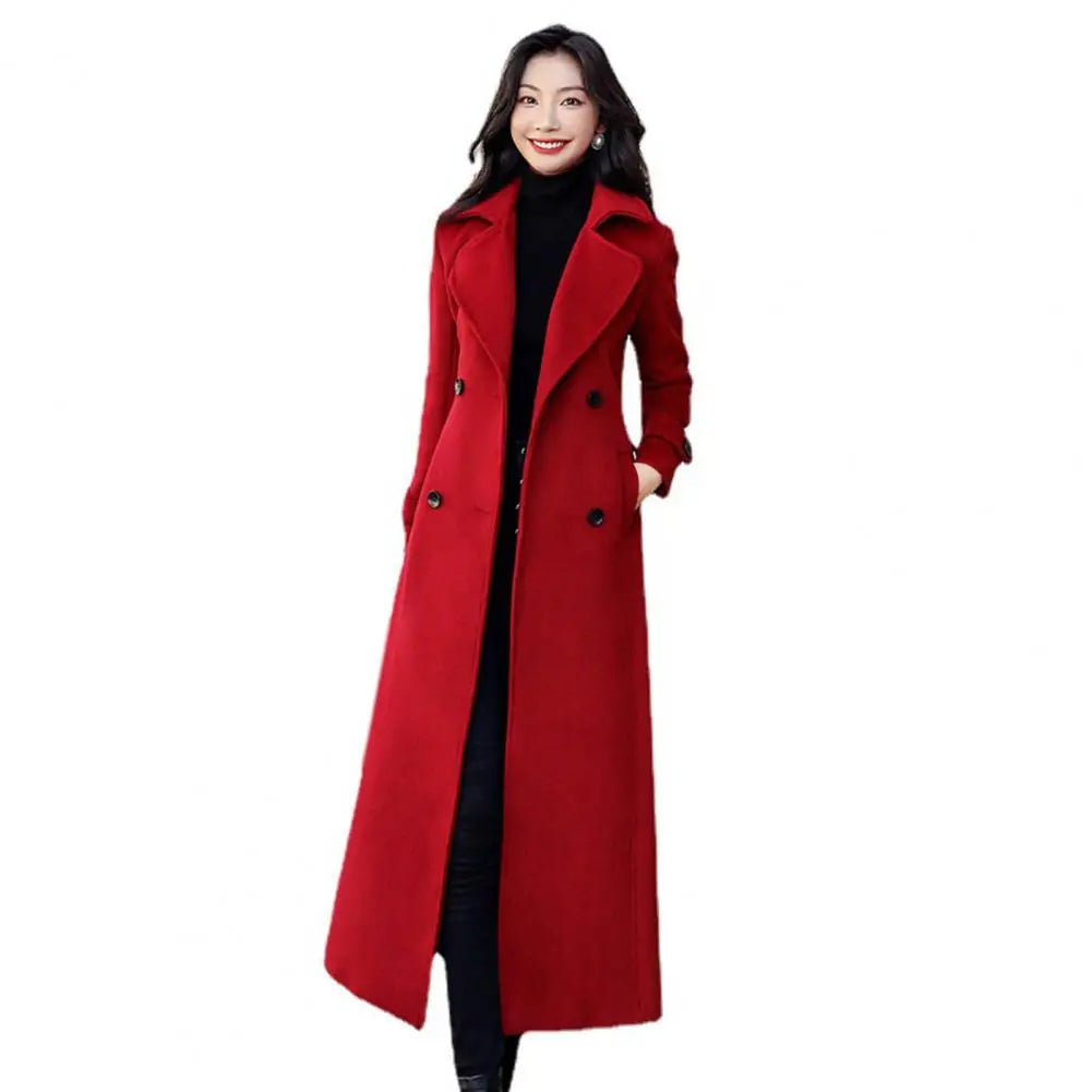Woman wearing a long red coat on a white background