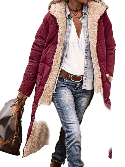 Person wearing a long burgundy puffer coat with beige lining, blue jeans, and a white shirt.